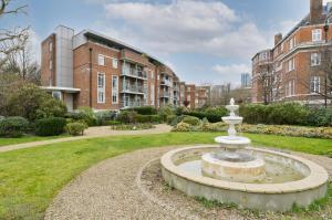 a fountain in a park in front of a building at Large one bedroom flat with balcony close to the City by UnderTheDoormat in London