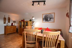 - une salle à manger avec une table et des chaises en bois dans l'établissement "Beim Brugger", à Lechbruck am See