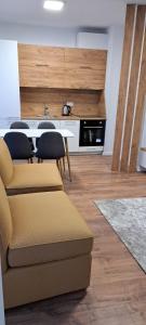 a living room with a table and chairs and a kitchen at Street C apartment nr 2 in Pristina