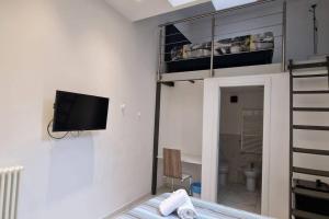 Residence Jolly في ميلانو: غرفة نوم مع سرير بطابقين وتلفزيون على الحائط