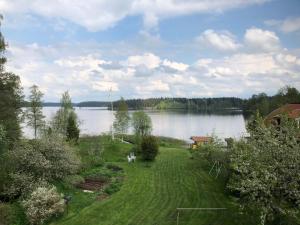 een tuin met een meer op de achtergrond bij Stort hus med trädgård - sjötomt med egen båt 