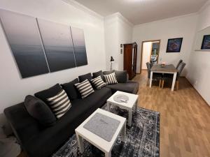 a living room with a black couch and a table at Meerblick Apartments Villa Vineta Göhren in Göhren