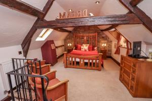 a bedroom with a red bed in a attic at Cholmley Cottage in Whitby