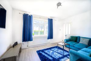 a living room with a blue couch and a window at Starview Apartment-Manchester Airport in Manchester