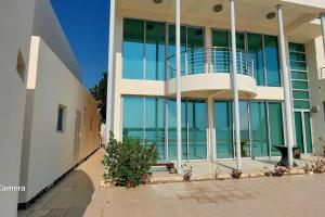 a large building with glass windows and a balcony at Family friendly house in Bahrian in Durrat Al Bahrain