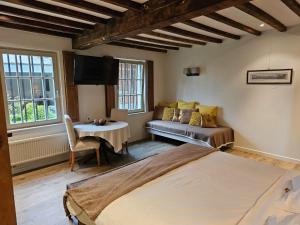 a bedroom with a bed and a couch and a table at Eyckenmolen B&B in Lierde