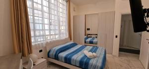 sypialnia z łóżkiem i dużym oknem w obiekcie Residence Jolly w Mediolanie