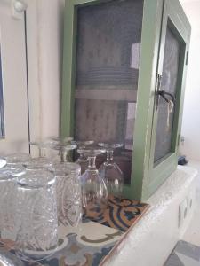 Kerames的住宿－The Village House，架子上装有透明玻璃花瓶的柜台