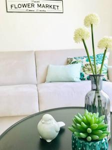 a glass table with a vase and a bowl of green bananas at Superbe Studio au cœur du Centre-Ville, proche mer in Nice