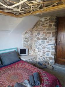 The Village House في Kerames: غرفة نوم بسرير وجدار حجري