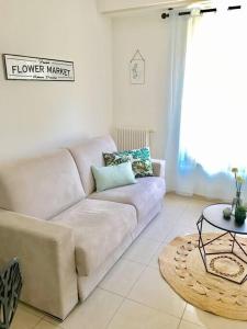 a living room with a white couch and a table at Superbe Studio au cœur du Centre-Ville, proche mer in Nice