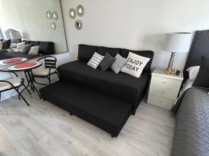 a living room with a black couch and a table at Buenos Aires desde las alturas in Buenos Aires