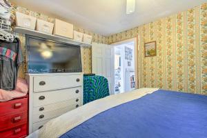 a bedroom with a bed and a dresser with a tv at Hartford Cottage with Dock and Private BCH on Bear Pond in Hartford