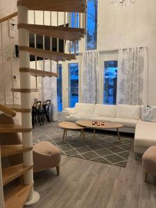 uma sala de estar com um sofá branco e uma mesa em Luxurious Villa Snow with Jacuzzi em Rovaniemi