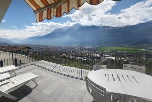 a balcony with a table and chairs and a mountain at Appartamenti Bioula CIR Aosta n 0247 in Aosta