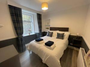 a bedroom with a large bed with two pillows on it at Strathisla Garden Apartment, Oban in Oban