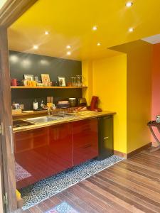 eine Küche mit gelben und orangefarbenen Wänden und einem Waschbecken in der Unterkunft Aluna Ecolodge in Petit-Bourg