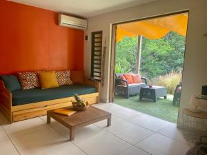 a living room with a couch and a table at Aluna Ecolodge in Petit-Bourg