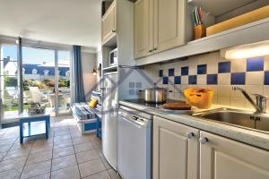 een keuken met een wastafel en een aanrecht bij LocaLise - Maison E2 au Guilvinec - A 20m de la mer avec jardin et piscine - Tout à pied, plage, port, centre commerces, marché - Wifi inclus - Vue mer de la chambre - Animaux bienvenus - Linge de lit inclus in Le Guilvinec