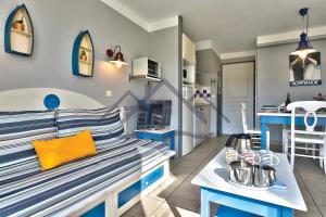 ein Wohnzimmer mit einer Bank und eine Küche in der Unterkunft LocaLise - Maison E2 au Guilvinec - A 20m de la mer avec jardin et piscine - Tout à pied, plage, port, centre commerces, marché - Wifi inclus - Vue mer de la chambre - Animaux bienvenus - Linge de lit inclus in Le Guilvinec + 49 Fotos