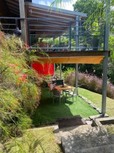 d'une terrasse avec une table et des chaises dans le jardin. dans l'établissement Aluna Ecolodge, à Petit-Bourg