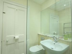 Un baño con lavabo, inodoro y espejo. en 2 York House, en Dartmouth 23 fotos más