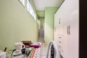 een wasruimte met een wastafel en een wasmachine bij Quarto com banheiro para solteiros no Rio de Janeiro in Rio de Janeiro