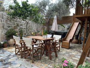 un patio con mesa, sillas y piano en MK Cottage With Breakfast and Jacuzzi en Sárkhos