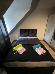 a bedroom with a black bed with two pillows at Zentrum MG Zimmer auf Zeit in Mönchengladbach