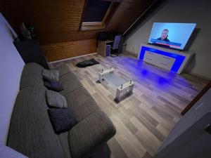 ein Wohnzimmer mit einem Sofa und einem Flachbild-TV in der Unterkunft Zentrum MG Zimmer auf Zeit in Mönchengladbach