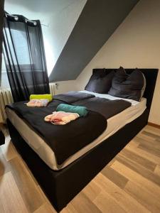 a large bed with two people laying on it at Zentrum MG Zimmer auf Zeit in Mönchengladbach