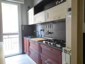 a kitchen with wooden cabinets and a sink and a stove at Appartamento Lora in Como