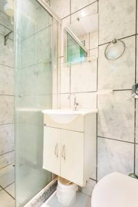 uma casa de banho com um lavatório e um chuveiro em Quarto com banheiro para solteiros no Rio de Janeiro no Rio de Janeiro