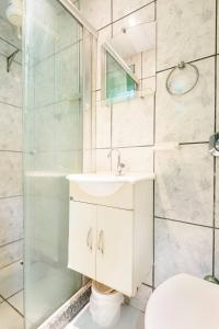 un baño con lavabo y ducha en Suíte para solteiro em ambiente familiar, en Río de Janeiro