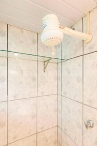 a bathroom with a shower with a glass door at Quarto com banheiro para solteiros no Rio de Janeiro in Rio de Janeiro