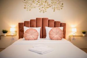 a bedroom with a large bed with pink pillows at Apartament Zafi Lakeview in Constanţa