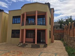 ein großes Haus mit rosa Säulen davor in der Unterkunft JM Apartment in Kigali