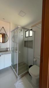 a bathroom with a toilet and a glass shower at Apto Luxo em Porto de Galinhas/PE in Porto De Galinhas