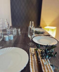 una mesa de madera con platos y copas de vino. en Mermaid Holiday Apartments en Mandria