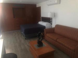 uma sala de estar com uma cama e um sofá em Posada 53 em Mazatlán