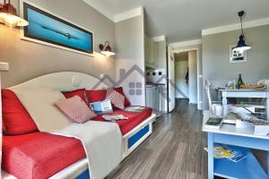 um pequeno quarto com uma cama e um sofá vermelho em LocaLise au Guilvinec - B5 - Plain-pied avec piscine et jardin - Tout à pied, plage, port, centre, commerces, marché - Wifi inclus - Linge de lit inclus - Animaux bienvenus em Le Guilvinec