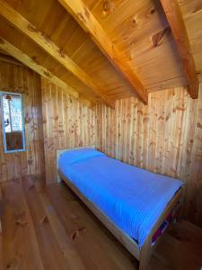 a bedroom with a bed in a wooden cabin at Cabañas los Patitos in Pucón