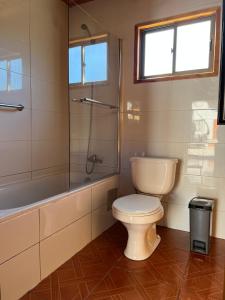a bathroom with a toilet and a glass shower at Cabañas los Patitos in Pucón +12 photos