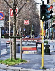 un semaforo su una strada cittadina con un cartello di Aania di Hotel Campion a Milano