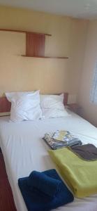 ein Bett mit weißer Bettwäsche und Handtüchern darauf in der Unterkunft CAMPING LE BEL AIR mobil home LE FIGUIER 6 personnes in Limogne-en-Quercy