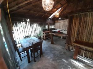 a room with a table and benches in a hut at Aldea Yuyu in Tulum
