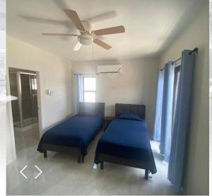 a bedroom with two beds and a ceiling fan at 2 Bedroom House in Discovery Bay