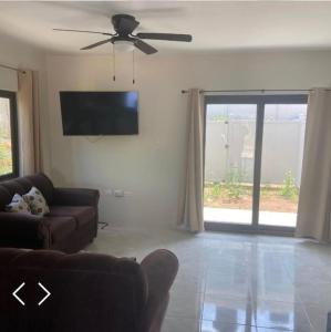 a living room with a couch and a ceiling fan at 2 Bedroom House in Discovery Bay