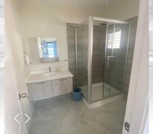 a bathroom with a glass shower and a sink at 2 Bedroom House in Discovery Bay