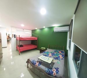1 dormitorio con cama y pared verde en Remodeled Downtown Apartment - Centro de Guayaquil, en Guayaquil